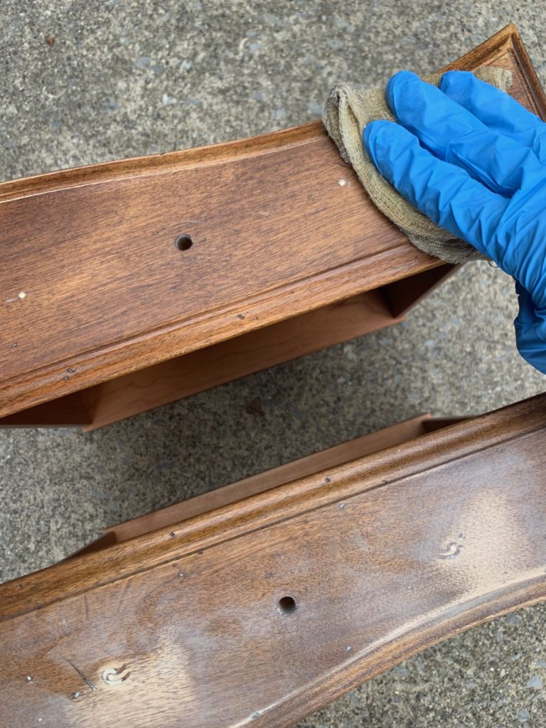 drawers of a wood console table that have been filled in order to replace furniture hardware on the piece. The extra holes were filled with bondo and sanded down