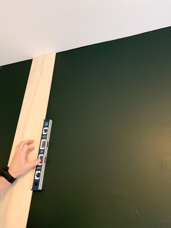 Use a straight board or long level to mark the stud from the top of your wall to the bottom. This is where you will nail your planks into the wall