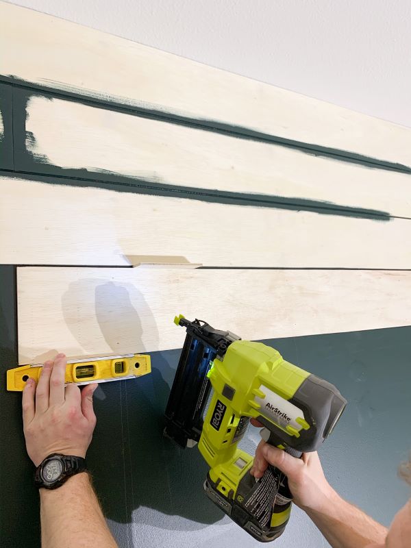Nail into the studs using a brad nailer, once you have your boards in place and confirm they are level. Continue laying for your plank wall