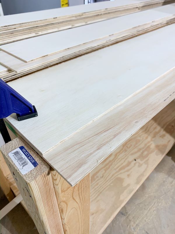 Creating a guide board with a straight edge and clamps can be used to cut down plywood planks without a table saw.