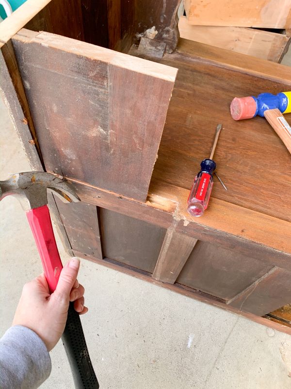 How to deconstruct a vanity to turn it into end tables - use a hammer to remove nails from the wood sections to be removed after your vanity is cut in half