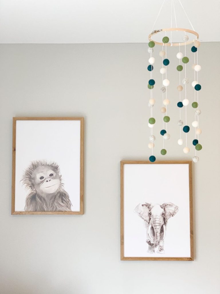 white and wood monkey and elephant nursery print in baby boy nursery reveal with felt ball mobile.