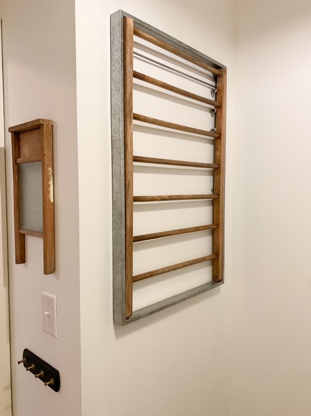 Laundry room refresh using wall mounted drying rack with galvanized metal and natural wood accents